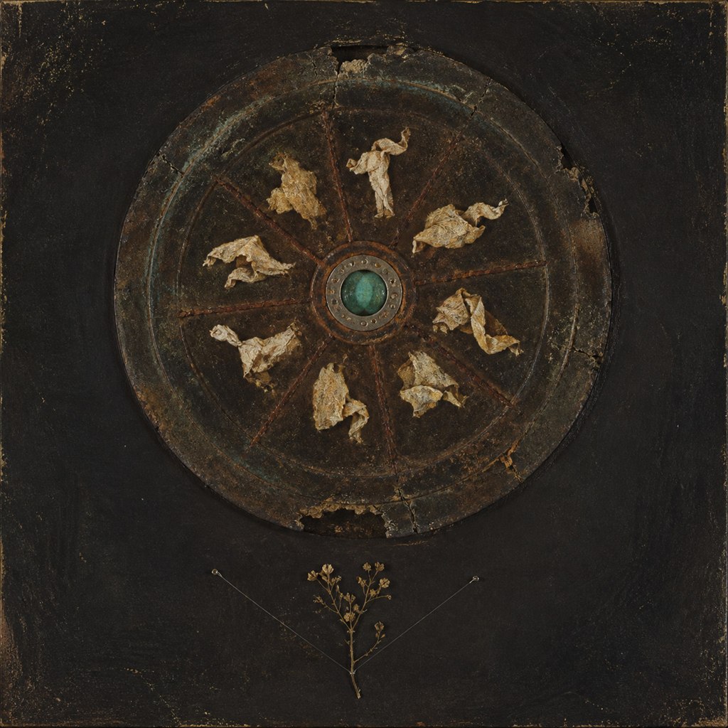 Wheel of Quiet Relics: aged votive wheel, carved bone figures, teal jewel core, cracked lacquer panel.